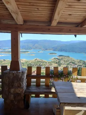 a porch with a bench and a view of a lake at Kuća za odmor Vidikovac in Rumboci