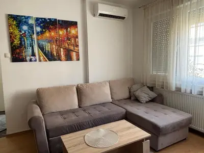 a living room with a couch and a painting on the wall at Apartman Urbana Oaza in Banja Luka