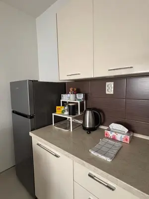 a kitchen with a black refrigerator and white cabinets at Apartman Urbana Oaza in Banja Luka