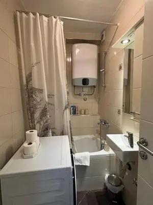 a small bathroom with a tub and a sink at Apartman Urbana Oaza in Banja Luka