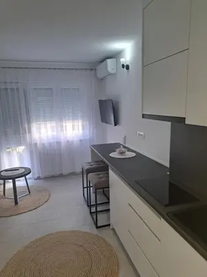 a kitchen with a black counter top and a table at Apartman Lamini in Livno