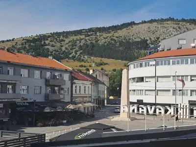 a city with buildings and a mountain in the background at Apartman Lamini in Livno