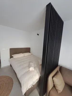 a small bedroom with a bed and a couch at Apartman Lamini in Livno