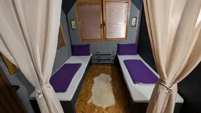 a small room with two beds and a dog in it at Vila N&M in Visoko