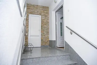 a stairway with a white door and a mirror at Apartman ATLAS in Jajce