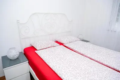 a bedroom with a bed with a red and white bedspread at Apartman ATLAS in Jajce