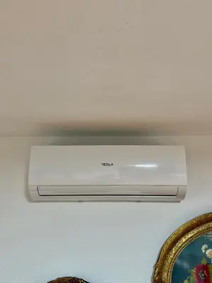 a white appliance on a wall next to a mirror at Apartman ATLAS in Jajce