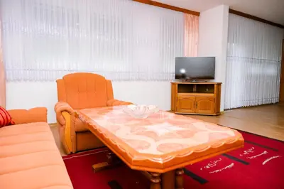 a living room with a table and a tv at Apartman ATLAS in Jajce
