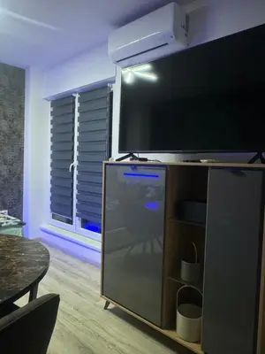 a living room with a large flat screen tv on a entertainment center at Apartman CITY CENTER 5 in Prijedor