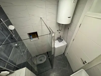 a bathroom with a glass shower and a toilet at Apartman CITY CENTER 5 in Prijedor