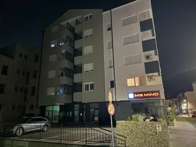 a car parked in front of a building at night at Apartman CITY CENTER 5 in Prijedor