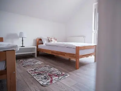 a bedroom with a bed and two rugs on the floor at Kuća za odmor -Megy- in Kupres