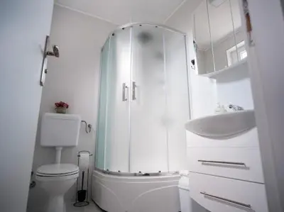 a bathroom with a shower and a toilet and a sink at Kuća za odmor -Megy- in Kupres