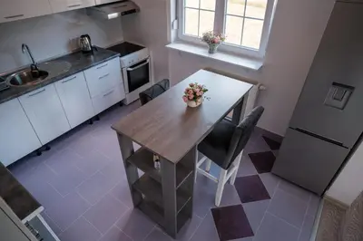 a kitchen with a wooden table and a sink at Kuća za odmor -Megy- in Kupres