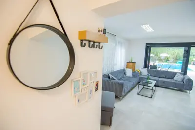 a mirror hanging on a wall in a living room at Villa Lea in Bihać