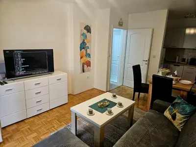 a living room with a couch and a tv and a table at Apartman Atina Doboj in Doboj