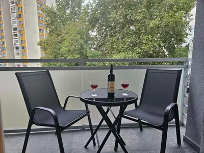 a table with two chairs and a bottle of wine on a balcony at Apartman Atina Doboj in Doboj