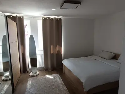 a small bedroom with a bed and a window at Apartman Mia Kupres in Kupres