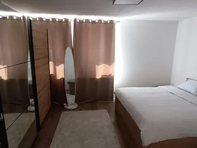 a small bedroom with a bed and a mirror at Apartman Mia Kupres in Kupres