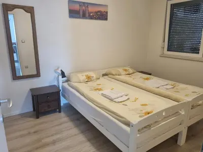 a bedroom with two beds and a mirror at Exclusive Kiseljak apartman in Kiseljak