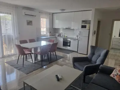 a kitchen and living room with a table and chairs at Exclusive Kiseljak apartman in Kiseljak