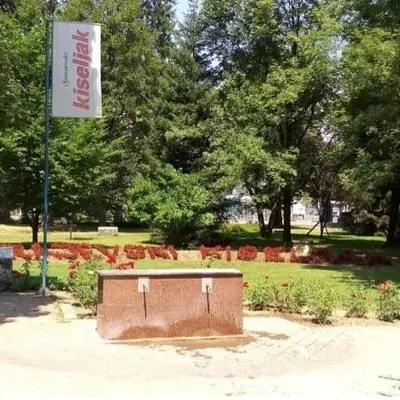 a park with a sign and a bench in a park at Exclusive Kiseljak apartman in Kiseljak