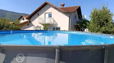 a large swimming pool in front of a house at OZIM oaza zelenila i mira in Podrašnica
