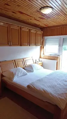 a bedroom with a large bed with a wooden ceiling at OZIM oaza zelenila i mira in Podrašnica