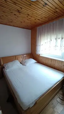 a large bed in a room with a window at OZIM oaza zelenila i mira in Podrašnica