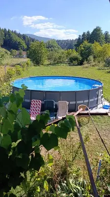 a pool in a field with two chairs next to it at OZIM oaza zelenila i mira in Podrašnica