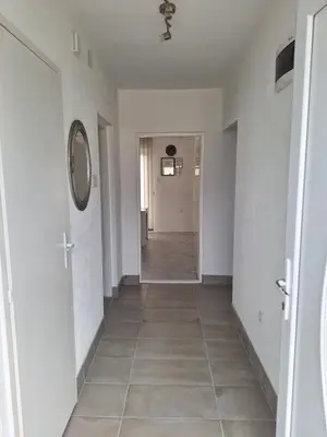 a hallway with white walls and a tile floor at Apartman Look in Jajce