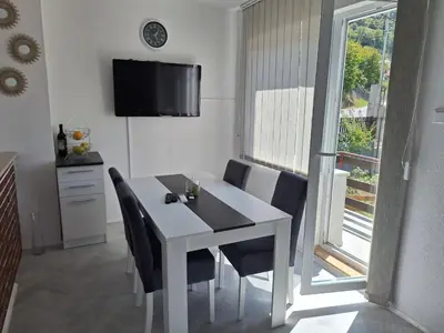 a white dining room table with chairs and a tv at Apartman Look in Jajce