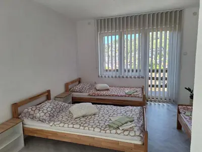 two beds in a room with two windows at Apartman Look in Jajce