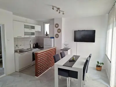 a kitchen and dining room with a table and chairs at Apartman Look in Jajce