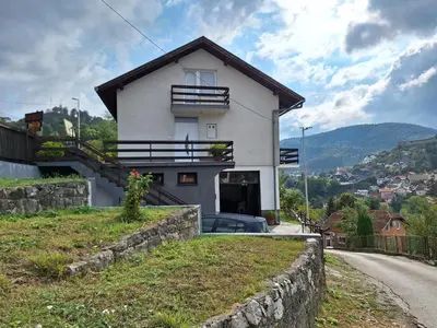 a white house on the side of a road at Apartman Look in Jajce