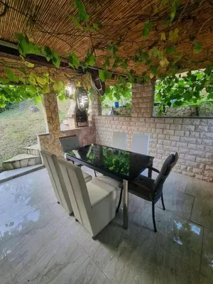 a dining table and chairs in a patio at Garden House in Tuzla