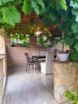 an outdoor patio with a table and chairs and ivy at Garden House in Tuzla
