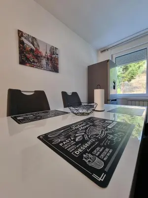 a kitchen with a table with a black and white placard on it at Garden House in Tuzla