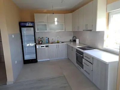 a kitchen with white cabinets and a black refrigerator at Villa Sunset in Banja Luka