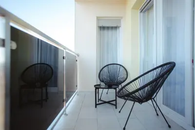 two chairs and a table on a balcony at Lux Apartmani Teslić in Teslić