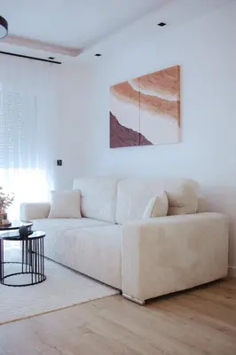 a living room with a white couch and a table at Lux Apartmani Teslić in Teslić