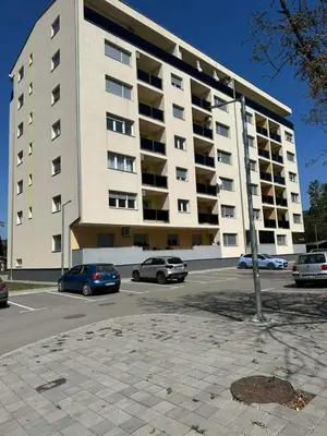 a large apartment building with cars parked in a parking lot at Lux Apartmani Teslić in Teslić