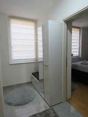 a room with a white refrigerator and a bedroom at Apartman City in Jajce