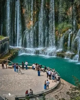 a group of people standing in front of a waterfall at Apartman City in Jajce
