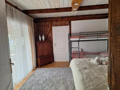a bedroom with two bunk beds and a brick wall at Lake house in Donji Žabar