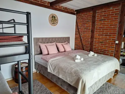 a bedroom with a bed with pink pillows and a brick wall at Lake house in Donji Žabar