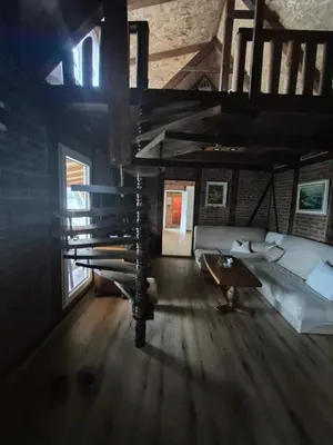 a room with a loft with a couch and a table at Lake house in Donji Žabar