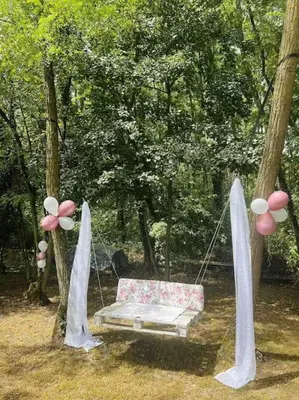a swing in a park with flowers on it at Lake house in Donji Žabar