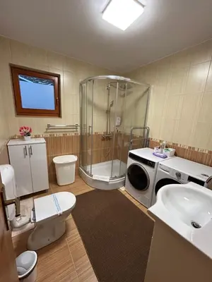 a bathroom with a shower and a washing machine at Montis Vlasic Apartment 1 in Vlasic
