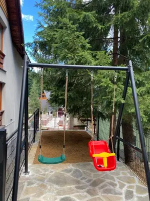 a playground with a swing set in a yard at Montis Vlasic Apartment 2 in Vlasic
